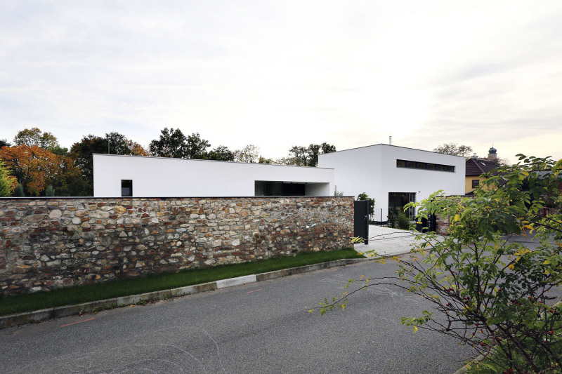 Rozhodnutí o zachování kamenné zdi bylo jasné od začátku. Autoři projektu tak zachovali romantiku místa i jeho historickou hodnotu. Oba domy se nacházejí zhruba osm metrů za ní, takže vznikl intimní prostor s odlišným charakterem od hlavní otevřené zahrady