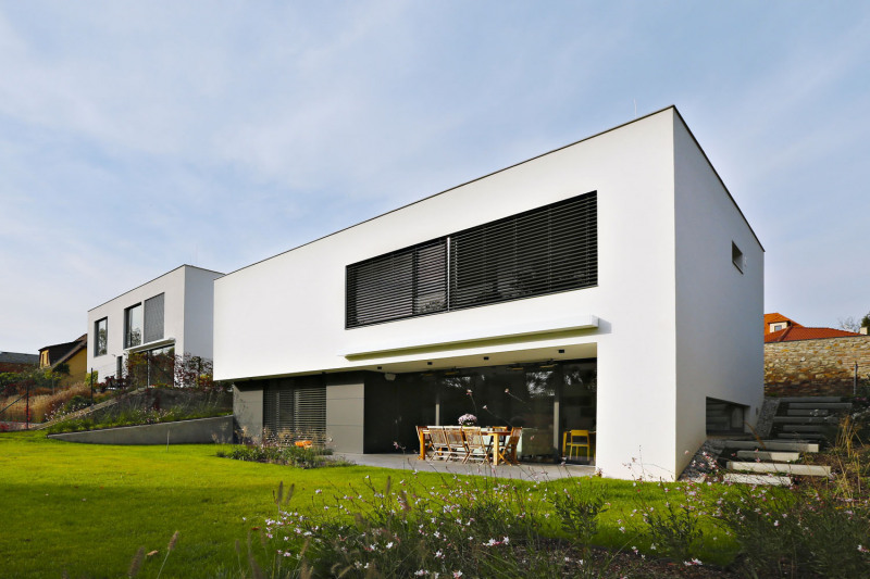 Jako první se stavěl dům stojící směrem na západ. Návrh od architektů Eriky a Vladimíra Vašutových ovlivnil první dojem z pozemku – krásná stará zeď, mírně se svažující terén k jihu, výhled na stromy a siluetu zámku