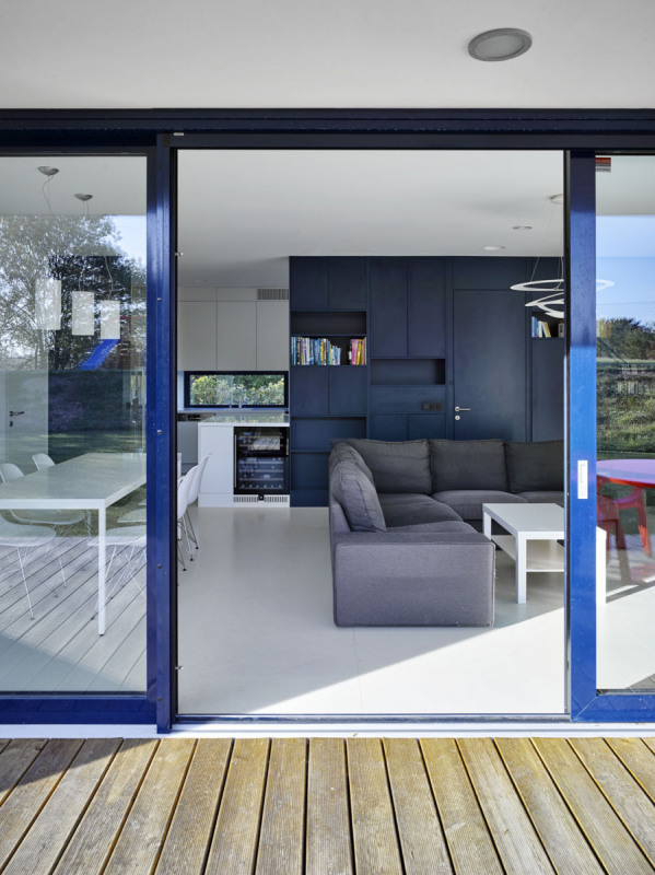 Hladké podlahy v pokojích přecházejí v dřevěnou terasu. Z obývacího pokoje a dětských pokojů se dá přímo v yjít ven na zahradu posuvnými prosklenými dveřmi s moderními HS portály