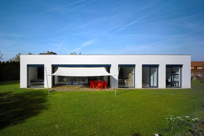 Domu dává výraz pravidelný řád oken s modrými rámy a přiznanými schránkami předokenních žaluzií. Modrá barva se opakuje i v interiéru