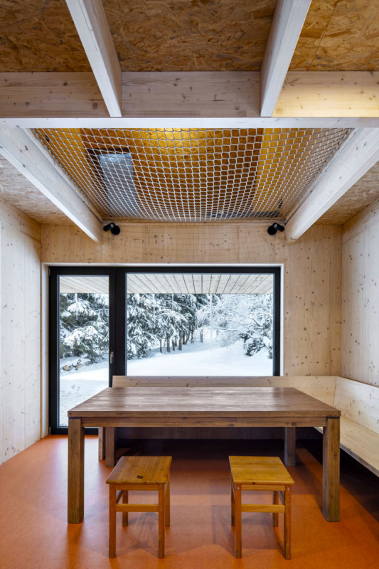 Pohled z kuchyňského koutu přes jídelní stůl na terasu a směrem ven