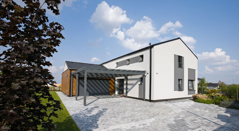 Zajímavým a praktickým prvkem je velké kryté garážové stání s dřevěnou konstrukcí a průhlednou akrylátovou střechou a také garáž s betonovým obkladem Pasada věrně imitujícím dřevo (dodává Baumit). Tento materiál je i na fasádě herny