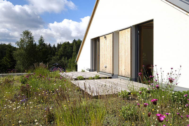 Na hlavních plochách fasády byla použita tenkovrstvá omítka v bílé barvě, doplňující plochy tvoří dřevěný fasádní obklad a terasy z modřínu bez povrchové úpravy