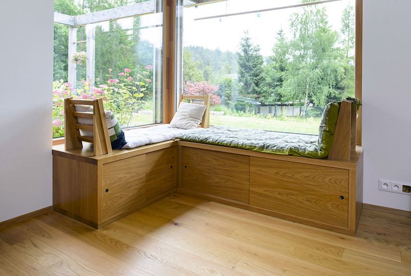 Z čtecího koutku, se sedacími parapety ukrývajícími praktické úložné prostory, se otevírají uklidňující pohledy do zahrady a blízkého lesa