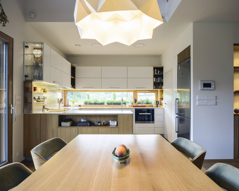 Hlavní obytný prostor zahrnuje obývák s čtecím koutkem se sedacími parapety a krbem, a kuchyň s praktickou spíží a jídelním koutem