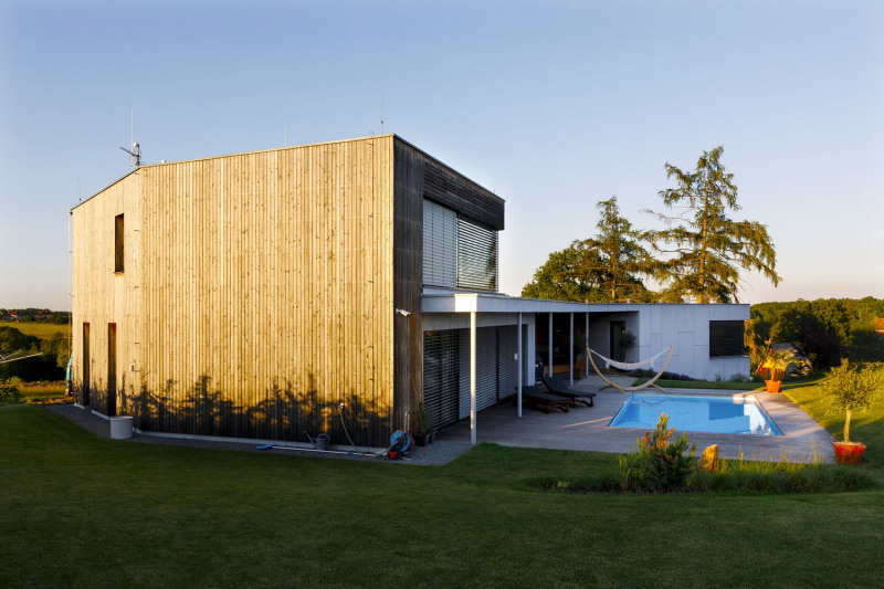 Osazení domu do terénu působí dynamicky a přitom lehce a přirozeně. Na fasádu jsou použity materiály s přírodním designem – modřínové latě a fasádní desky Cembrit