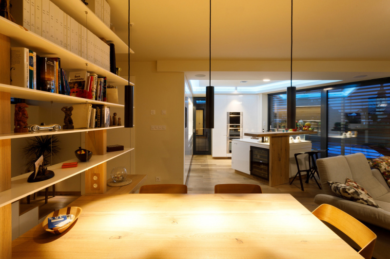 V hlavním prostoru mezi schodištěm a kuchyní je umístěn obývací pokoj s pracovním stolem i jídelním koutem