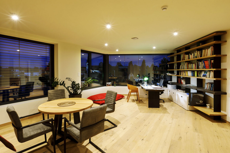 V hlavním prostoru mezi schodištěm a kuchyní je umístěn obývací pokoj s pracovním stolem i jídelním koutem