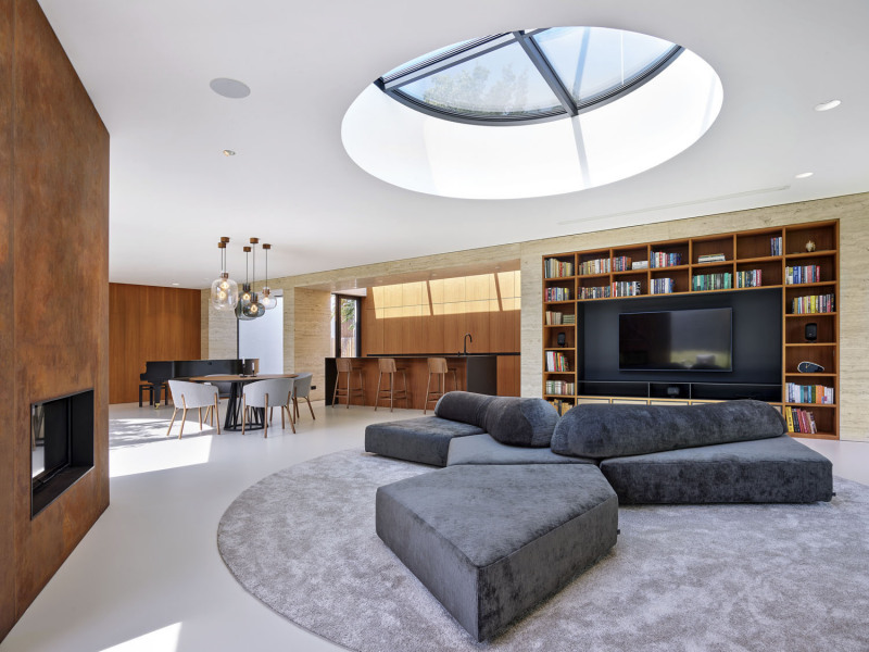 V interiéru architekti zkombinovali olejované dřevo s obklady z travertinu a cortenovým plechem, který je použit na krbovém tělese. Obývacímu prostoru dominuje atypické sezení. Velkorysá „trojcípá“ skládačka dává na výběr posezení s výhledem ke krbu, do atria, do zahrady nebo na televizi. Kromě prosklených stěn do domu přichází denní světlo také několika promyšleně rozmístěnými střešními světlíky. Západní slunce se tak dostane i tam, kam by jinak nemohlo proniknout