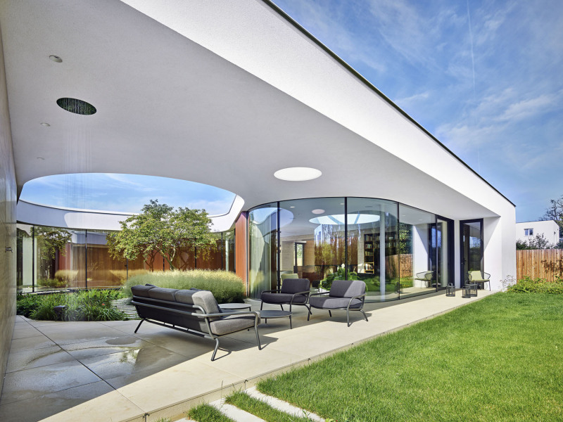 Díky prosklenému atriu kapkovitého tvaru se slunce dostane i do obytných místností orientovaných převážně na severní stranu do zahrady. Společný obývací prostor se nachází v pozici zaobleného nároží na rozhraní mezi atriem, krytou terasou a zadní částí pozemku s bazénem