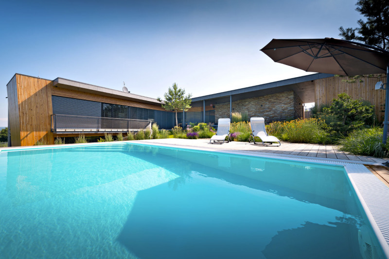 Zahrada je rozdělena do dvou výškových úrovní. První navazuje na přízemí domu a je ukončena bazénem, druhá výšková úroveň zahrady navazuje na dětské pokoje v nižším patře