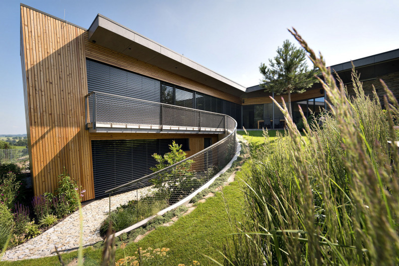 Zatímco křídlo rovnoběžné s příjezdovou komunikací je jednopodlažní, druhé dvoupodlažní křídlo je naopak kolmé na komunikaci a vstupuje dále do pozemku