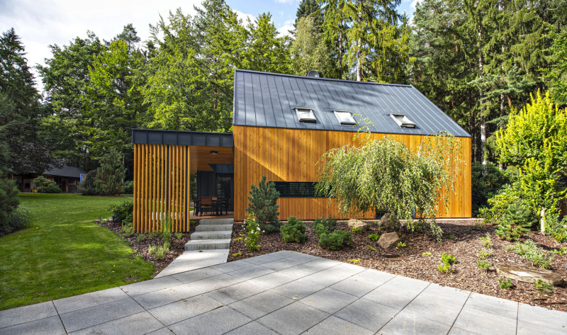 Fasády obou částí – původního domu se šikmou střechou i nové přístavby s horizontální střechou – sceluje dřevěný obklad ze sibiřského modřínu a plechová střešní krytina