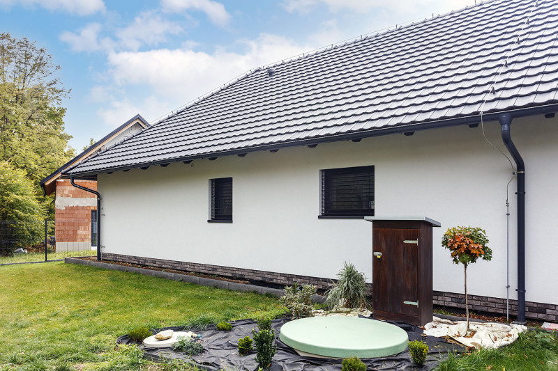 Nízký skládaný sokl, bílá fasáda a tmavá střešní krytina Tondach v břidlicové barvě nás odkazují na podhorské domy 19. století, uvnitř domu však vládne století jednadvacáté