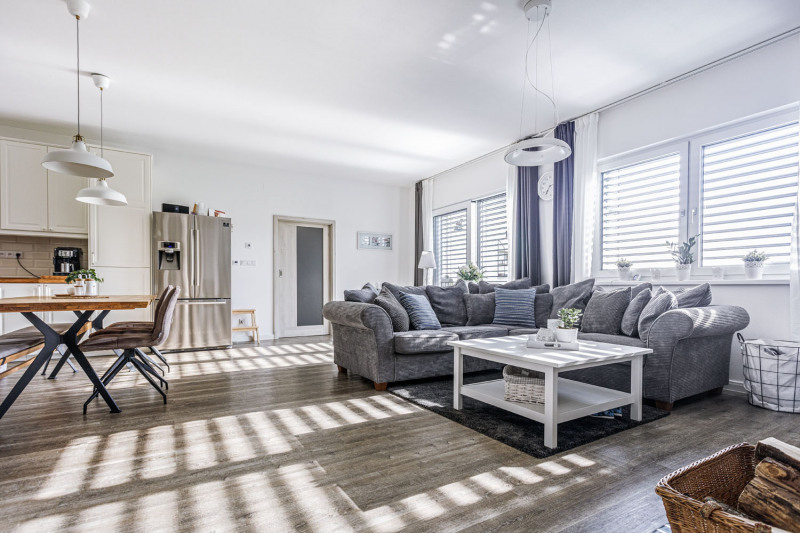 V hlavní obytné místnosti kromě jídelního stolu najdete i sedací soupravu do L se stolem v provensálském stylu. Prosklená plocha dostatečně zásobuje místnost přirozeným světlem