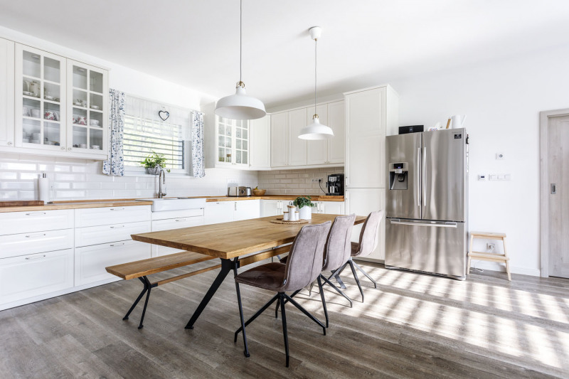 Kuchyně inspirovaná provensálským stylem s masivní dřevěnou deskou v přírodním odstínu. Stejný odstín najdete i na desce jídelního stolu a lavici minimalistické konstrukce