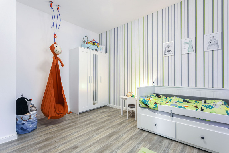Dětský pokoj skýtá dostatečný prostor pro dětské hry, kromě skříně slouží k ukládání prostor ve spodní části postele. V dětském pokoji nás zaujala i zavěšená sedačka ve formě opice