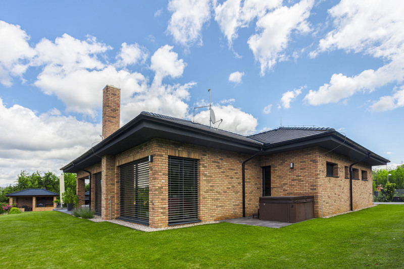 Díky členitému půdorysu a nízké valbové střeše nepůsobí dům ani přes velkou zastavěnou plochu příliš mohutně. Hlavní obývací prostory jsou orientovány na západ, k výhledu dolů ze svahu. Směrem na jih – k sousedům – vede jen jedno rohové okno, aby přivádělo do obývacího pokoje polední slunce. Vede sem také výstup z koupelny k příjemně chráněné vířivce