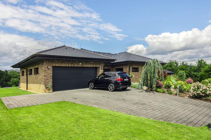 Před vjezdem do garáže byla vybudována odstavná zpevněná plocha ze zámkové dlažby, aby tu pohodlně zaparkovaly i návštěvy