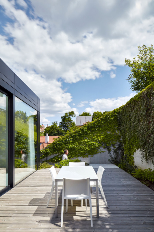 U boční fasády jsou dvě paralelní schodiště, oddělená tzv. kopilitovým sklem. Interiér je díky tomu příjemně prosvětlený, i když dispozice jsou vzhledem k úzké parcele poněkud stísněné