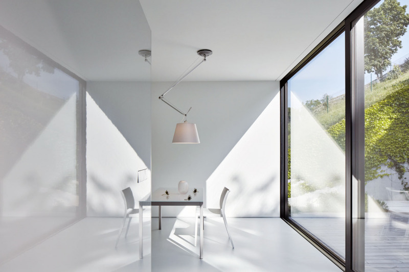 Velké okno, které propojuje jídelnu s terasou, je protějškem výhledu na opačné straně interiéru. Vede do ryze soukromé části, ukryté před zraky sousedů
