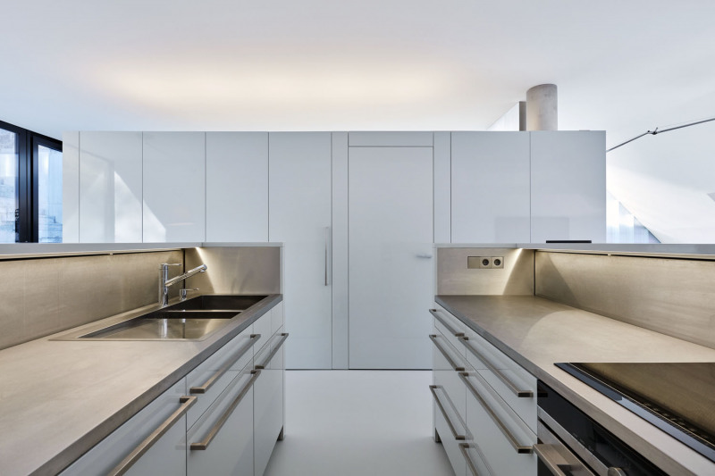 Interiér působí minimalisticky. Kuchyň je částečně vestavěná do uzavřeného boxu, v němž se nachází také spíž a WC