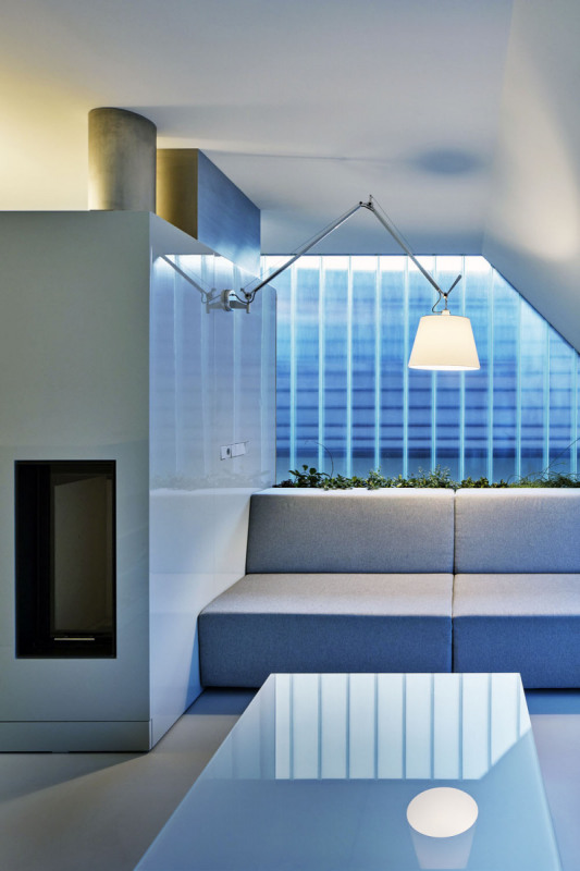 Lavice/pohovka je zabudovaná do stěn. Její kratší strana má za zády kopilitové sklo, díky tomu je odtud vidět až ke vstupním dveřím