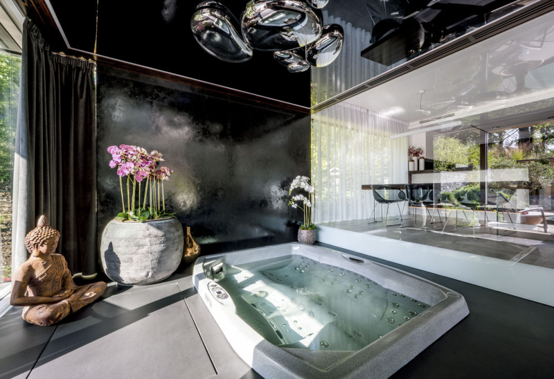 Orientální dekorace, černá leštěná stěrka a černá světelná stropní fólie dokládají, že zóna wellness byla inspirována Dálným východem. Vířivka je zapuštěna v železobetonové vaně v podlaze