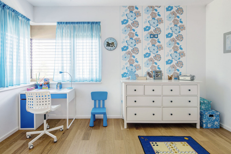 Interiér dětského pokoje sází na kombinaci bílých a světlemodrých barevných odstínů, to celé je „ukotveno“ podlahou v přírodním odstínu dubového dřeva