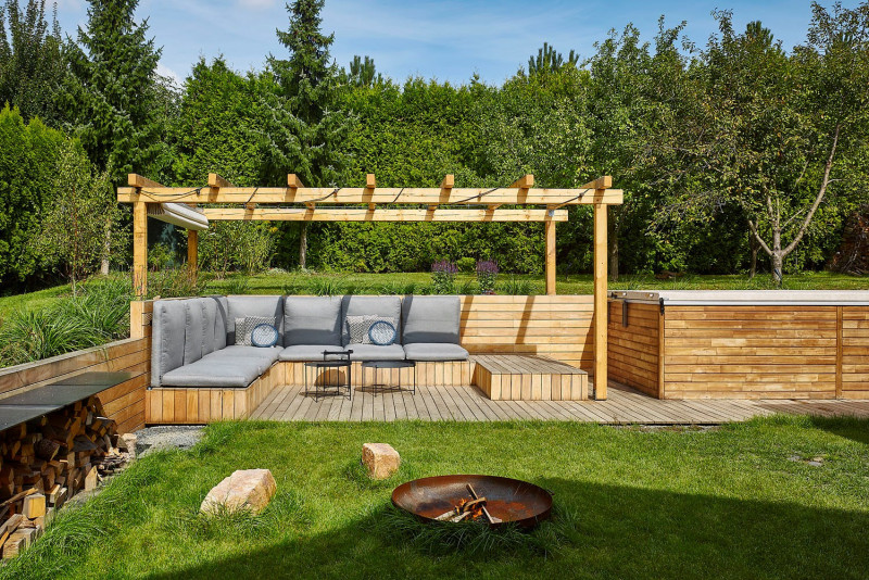 Do rohu zahrady architektka navrhla sezení s ohništěm, vířivkou a pergolou. Na stavbu pergoly byly využity i staré trámy z rozebraných střech