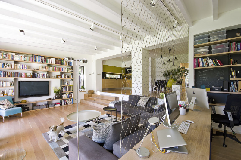 Velkou místnost se dvěma výškovými úrovněmi zdobí trámový strop natřený bílou barvou. Je to nenápadný, ale krásný prvek, který navíc dobře posloužil pro umístění osvětlení