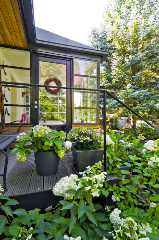 Dřevěná konstrukce verandy s ocelovými zasklívacími lištami má příjemnější členění než původní. Jednoduché linky kovového zábradlí jsou stejné venku i uvnitř