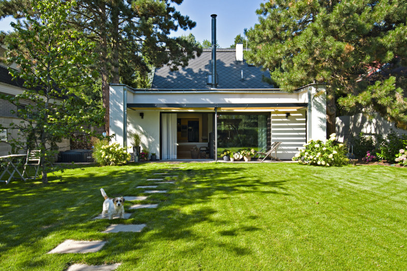 Velké okno do hlavního obytného prostoru propojuje interiér se zahradou tak, že máte pocit permanentních prázdnin. Střecha nad dřevostavbou je pultová