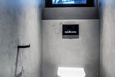 V koupelně a na WC architekt použil cementovou stěrku, velkoformátový obklad a dubové dřevo