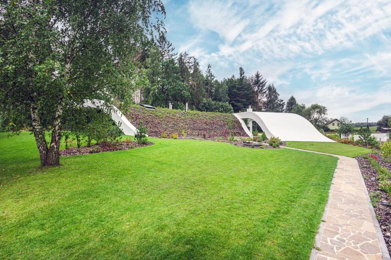 Pohled ze severní strany – střecha časem ještě více zaroste zelení a opticky splyne s horizontem lesa za domem