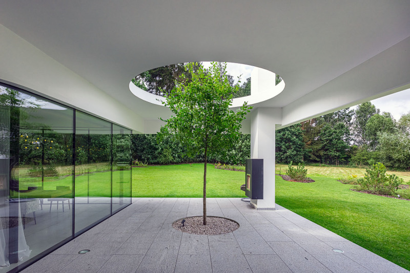 Strom prorůstající střechou symbolizuje propojení tohoto domu s přírodou i jeho ohleduplnost k životnímu prostředí, od hospodaření s vodou po nízkou energetickou náročnost