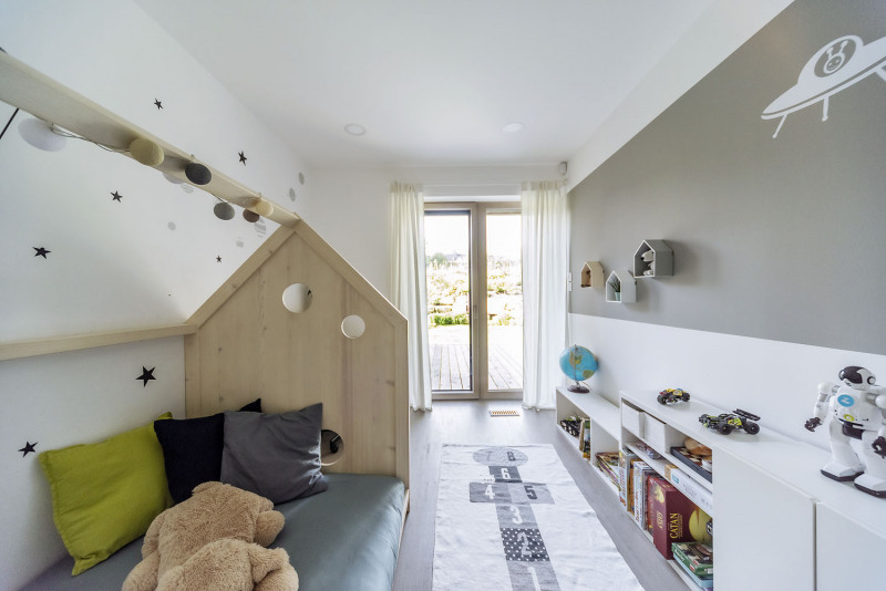 Ani inspirativní prostor dětského pokoje nezapře invenci svých tvůrců. Vtipně vyřešená postel s čelem ve tvaru archetypálního domu – tentýž motiv se opakuje v malém i na protější stěně