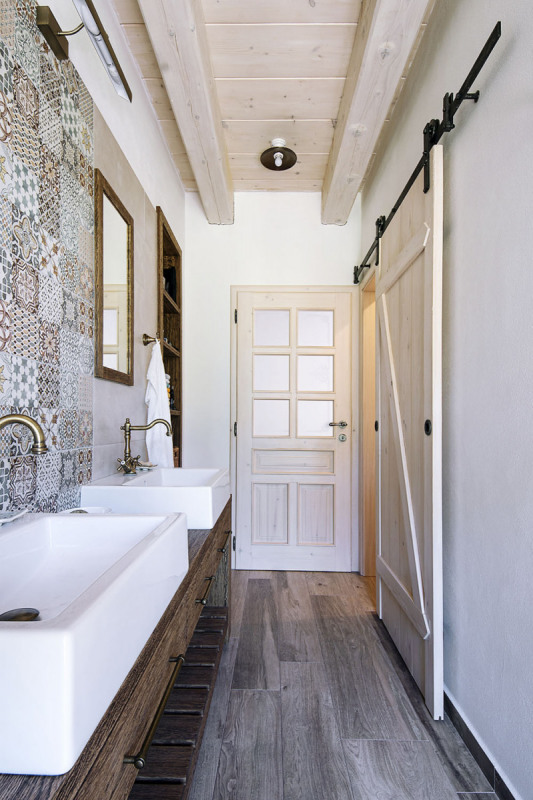 K ložnici majitelů patří vlastní koupelna s dvojumyvadlem a přilehlým WC. Působivý autentický výraz vytvářejí dřevěné a kovářské prvky v kombinaci s trámovými stropy