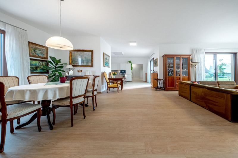 Velký moderní a vzdušný prostor s vinylovou podlahou s dekorem dubu se příjemně doplňuje s dřevěným nábytkem a vybavením v historizujícím stylu