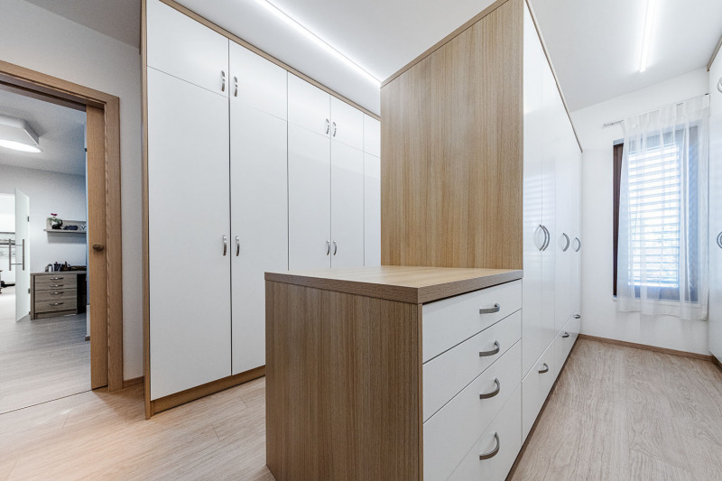 Šatna má cenné denní světlo a poskytuje velkorysý úložný prostor ve třech řadách vestavěných skříní vyrobených přesně na míru