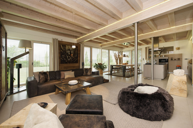 Hlavní obytné místnosti s kuchyní dominují přiznané dřevěné trámy, které ladí s originálním dřevěným nábytkem