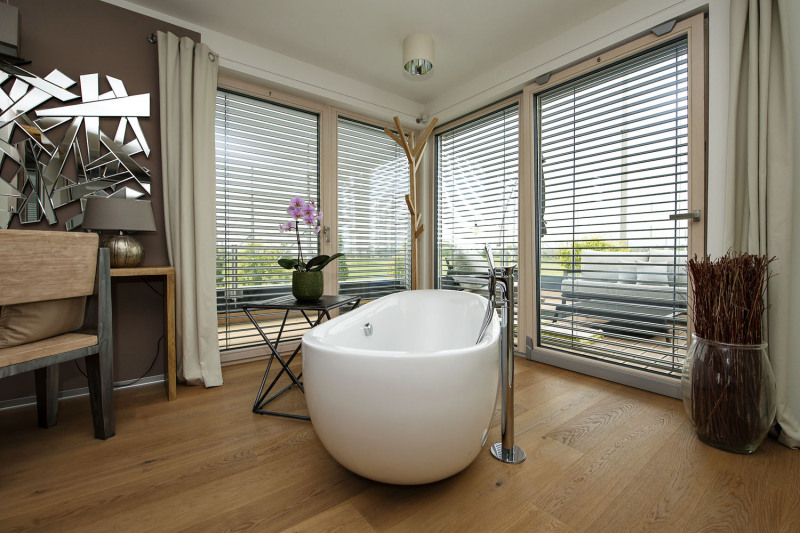 V horním patře majitelé relaxují koupelí s výhledem do okolí. Večer si dopřávají soukromí díky stínění