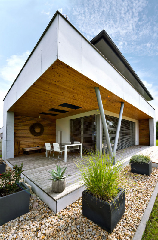 Dřevěné podhledy jsou šikovně schované před deštěm. Z boční strany je chrání fasádní desky Cembrit