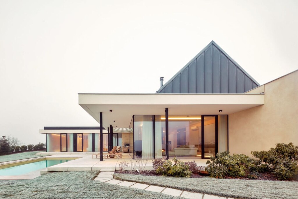 Prosklený skandinávský bungalov s terasou a bazénem, propojený s okolní krajinou